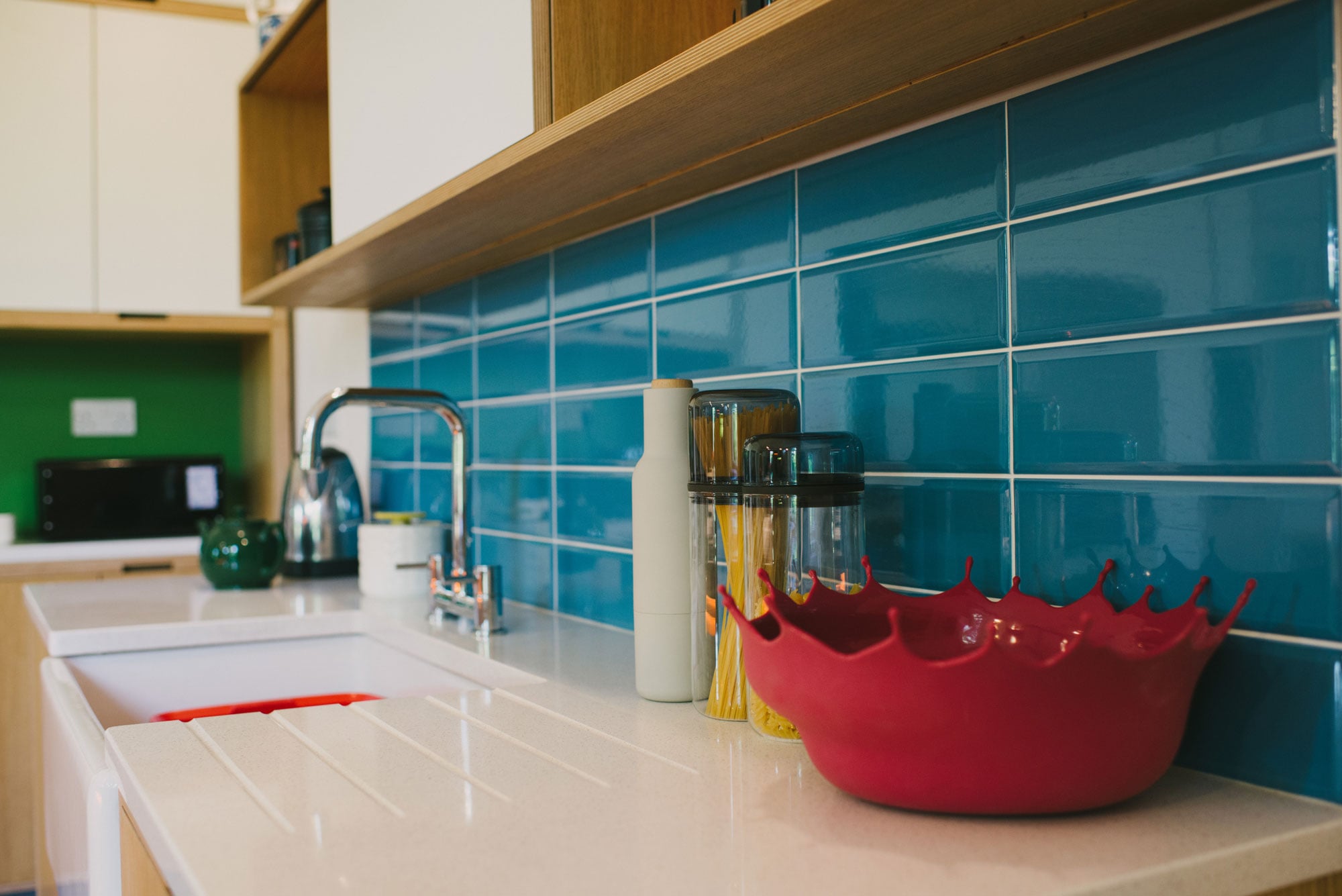 Red Menu drop bowl on white Corian kitchen worktop