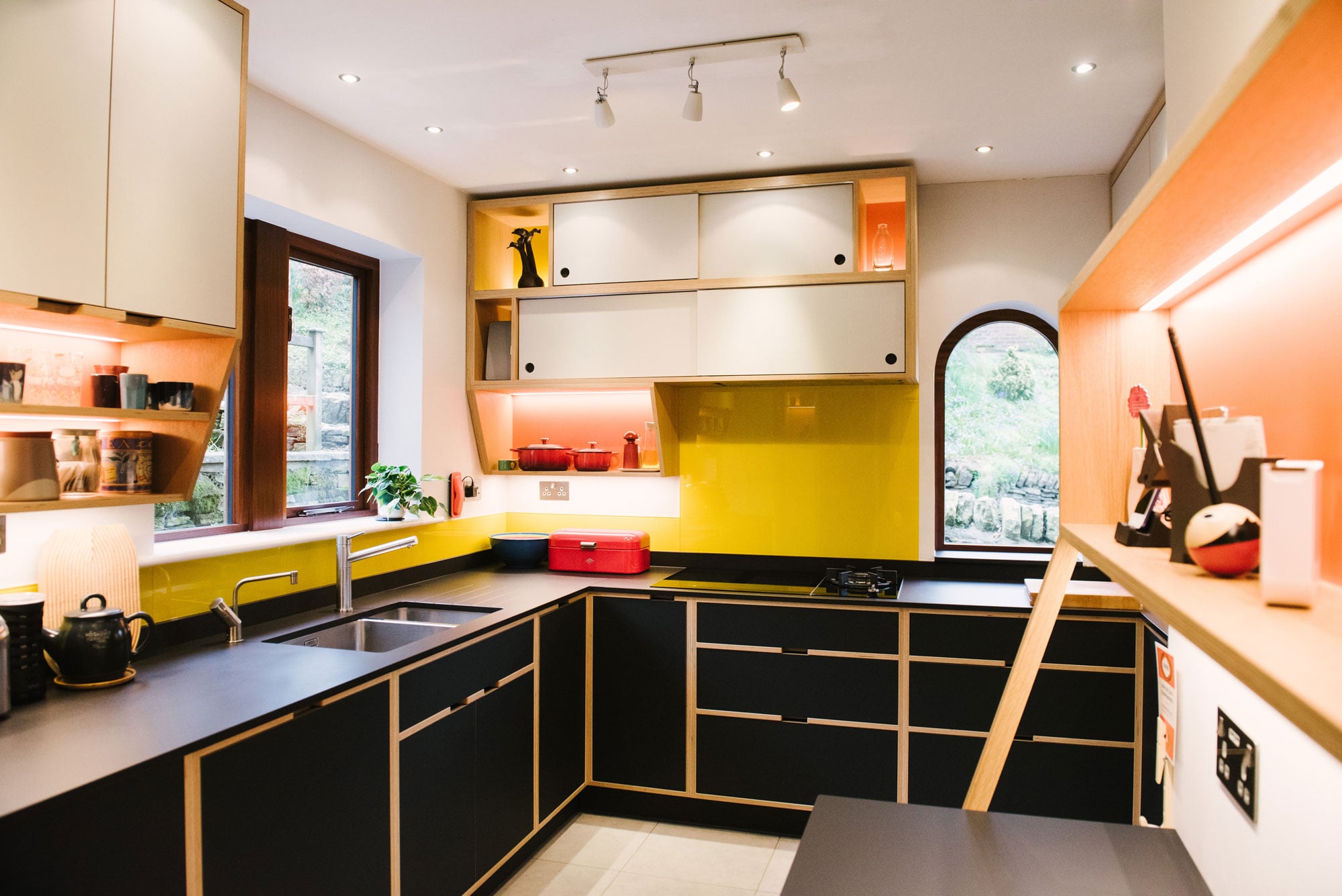 Sink Area of Black Plywood Kitchen with Yellow Splashback