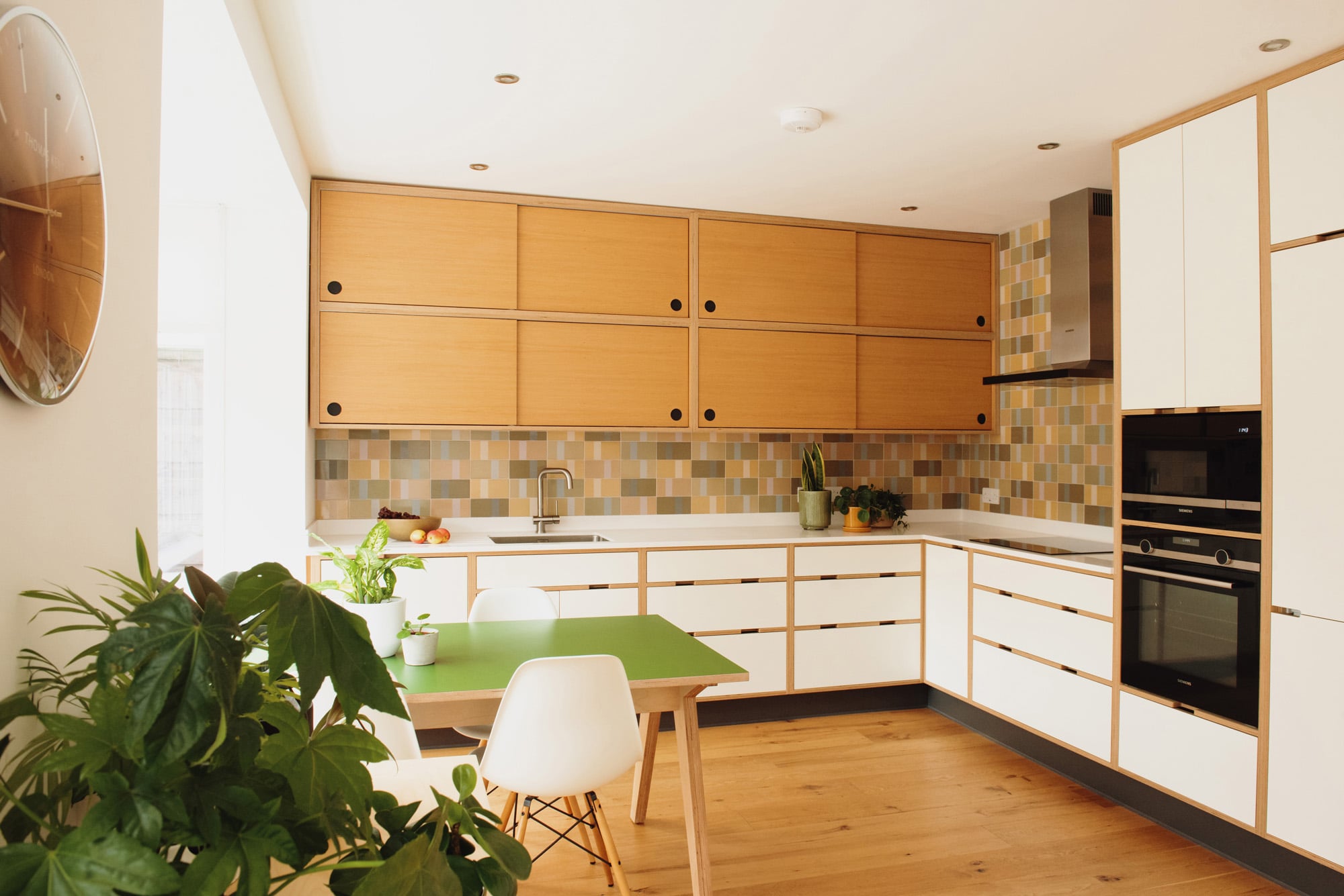 White plywood kitchen with double layer of oak sliding wall cupboards