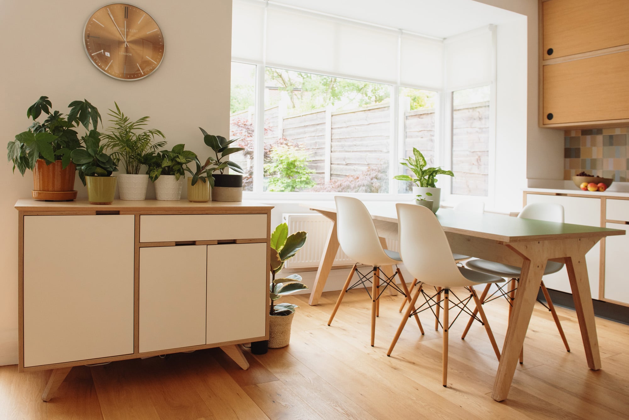 White plywood sideboard laden with indoor plants
