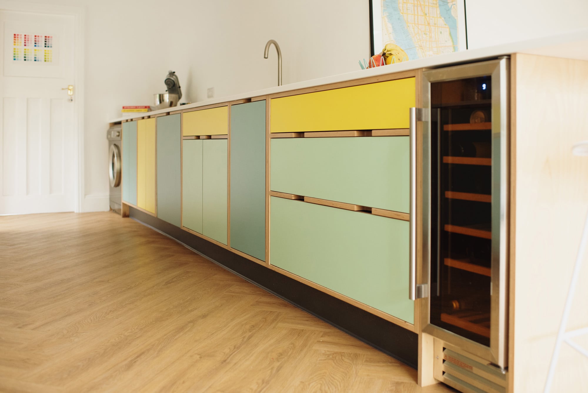 wine cooler in yellow and mint green plywood kitchen 