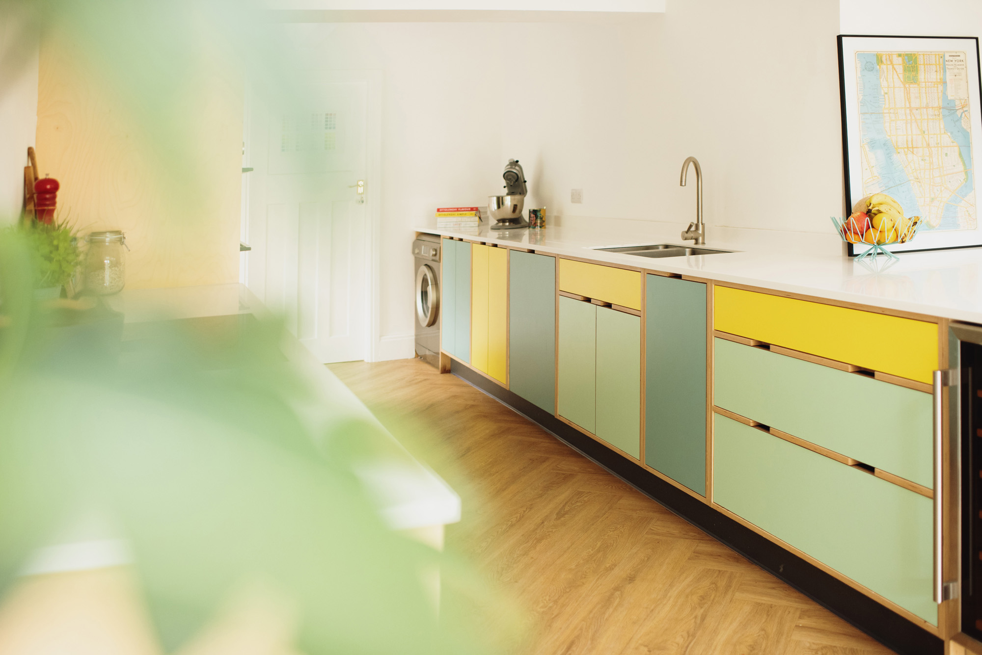sink area of yellow and mint green plywood kitchen