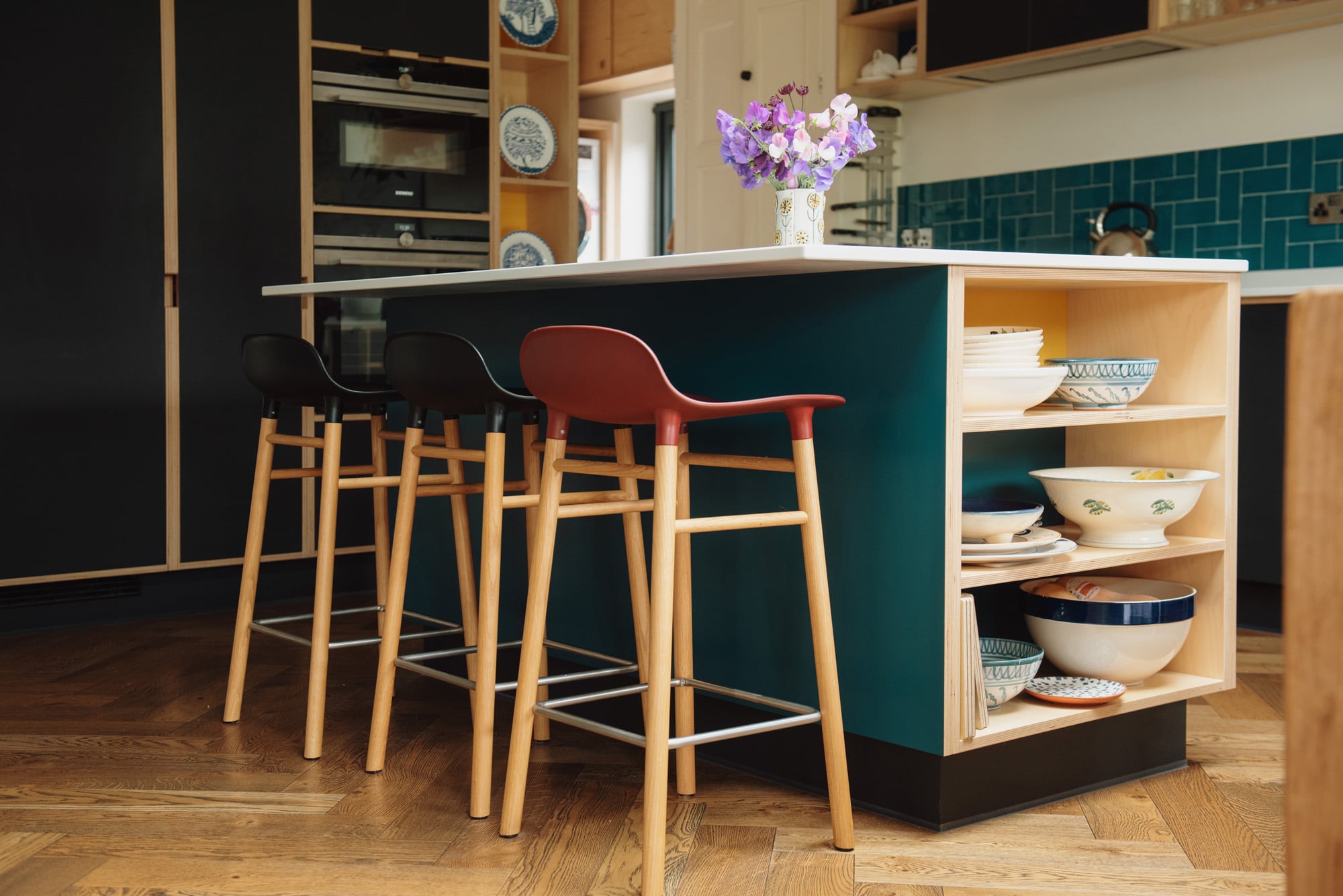 Open sided kitchen island with red and black bar stools