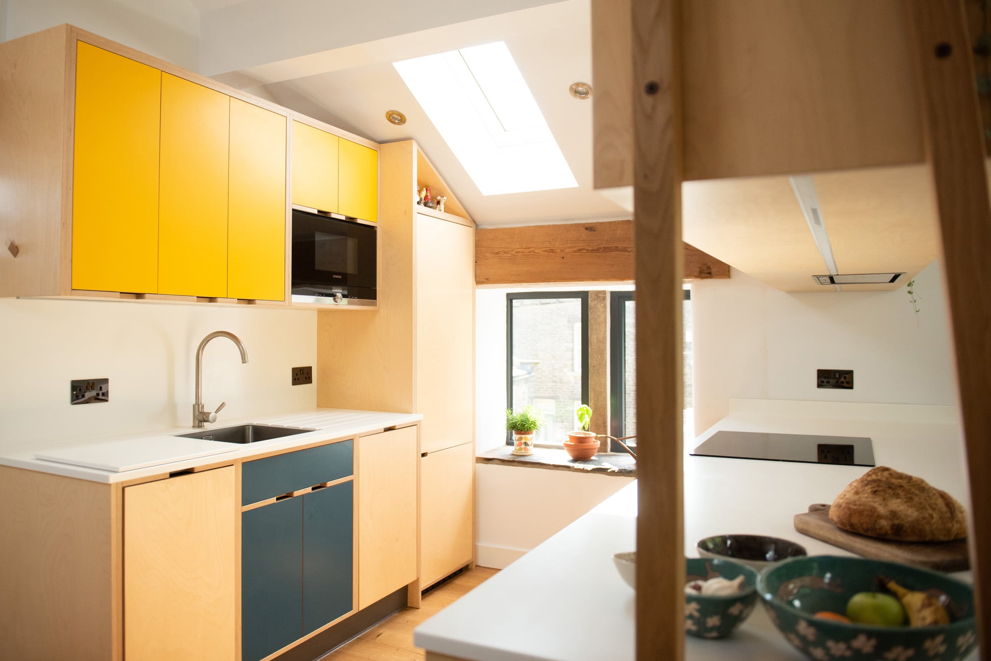 yellow and blue plywood kitchen in converted barn