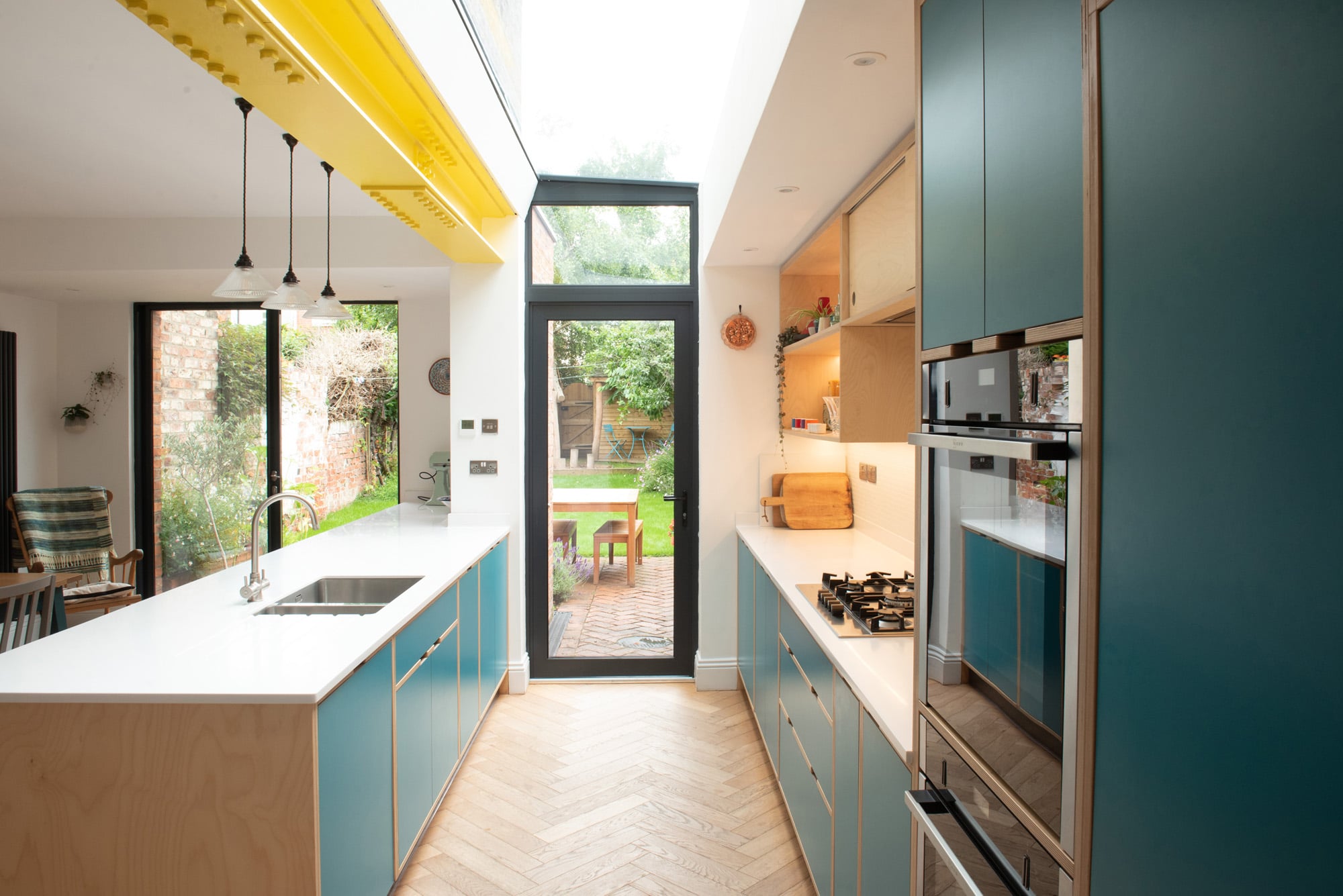 open plan plywood galley kitchen with yellow I beam