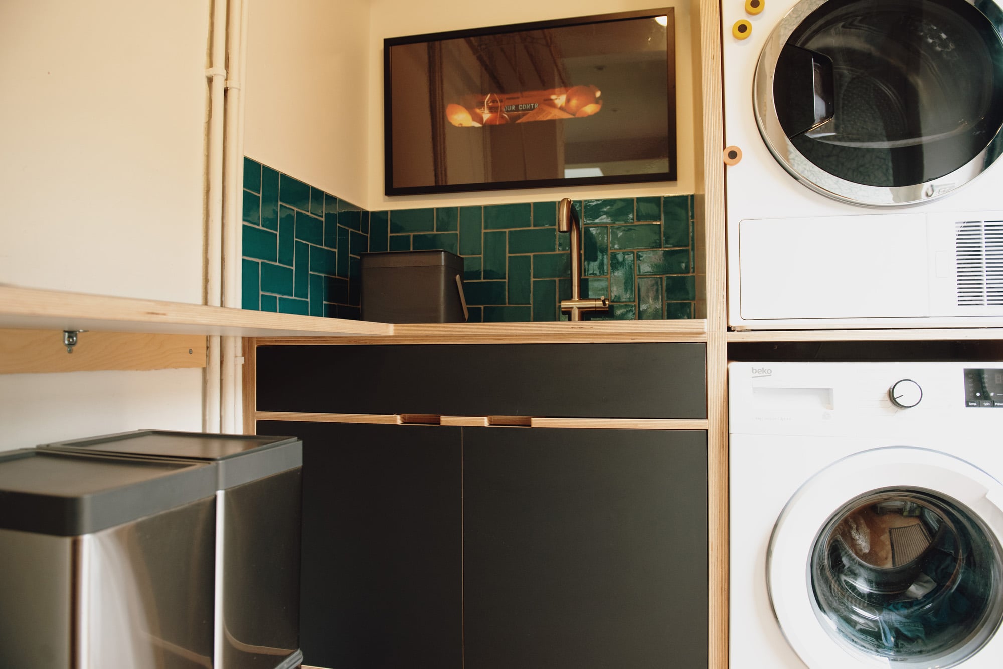 utility room with stacked washer dryer and sink area