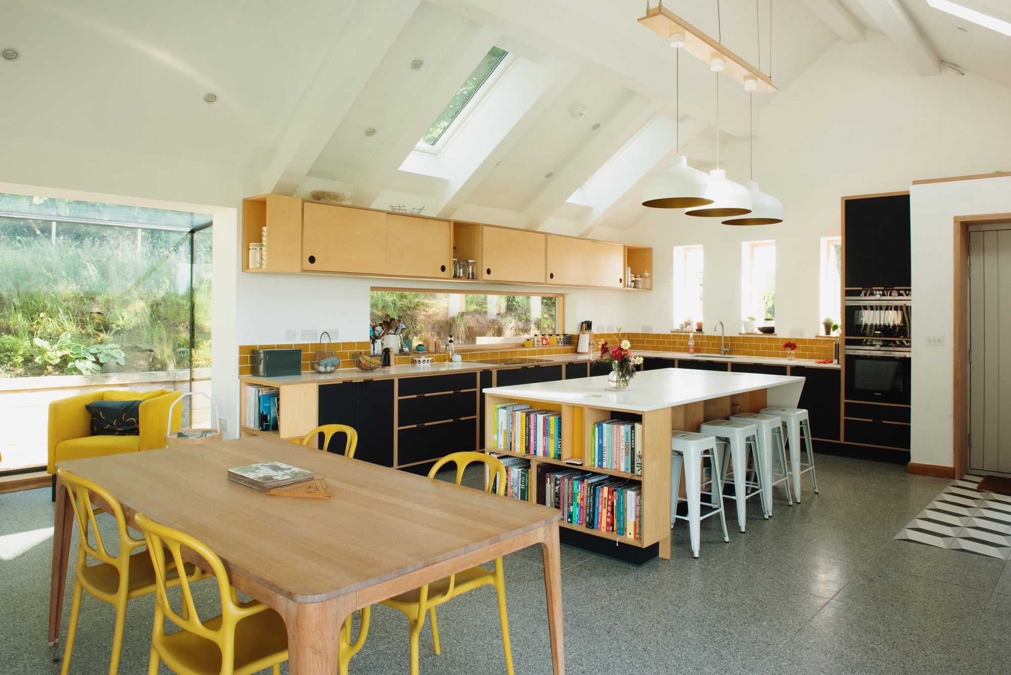 open plan kitchen and dining area with large windows and island unit 