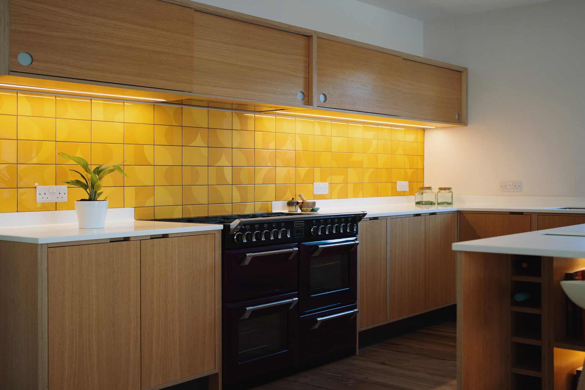 Oak Veneer kitchen with black range and Yellow Illuminated Tiles