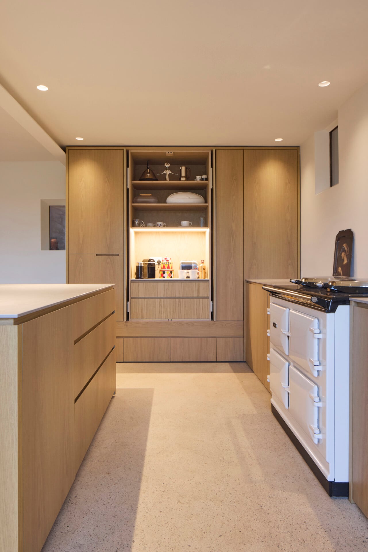 Barn kitchen with concealed oak pantry, white range cooker, and pale worktops