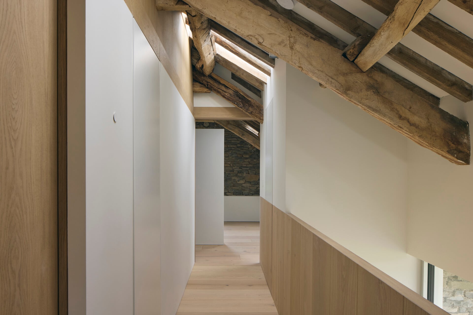 Upstairs landing in barn conversion with solid oak balustrade, oak flooring, and exposed rafters