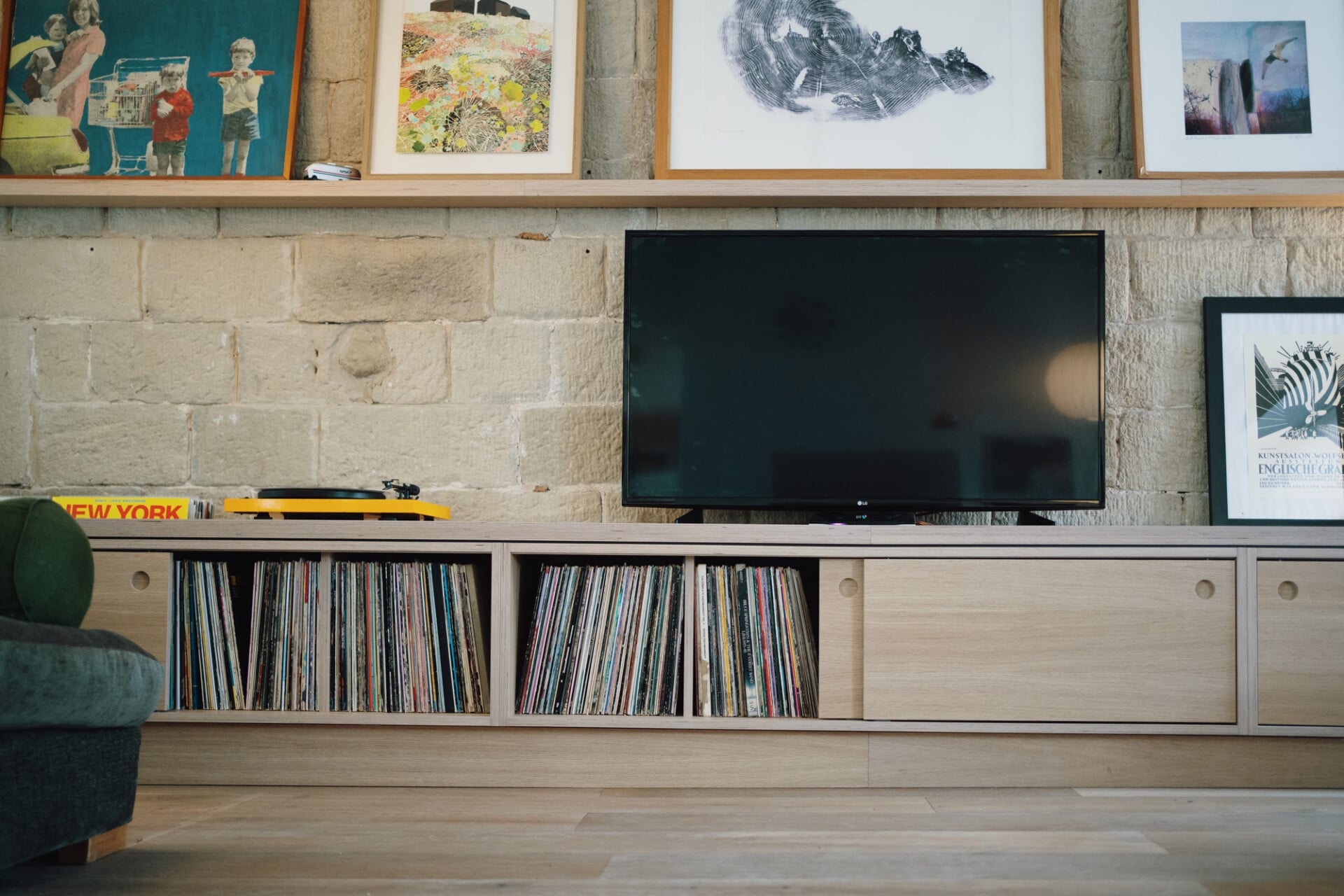Bespoke media unit with record storage, oak cabinetry, and wall-mounted TV