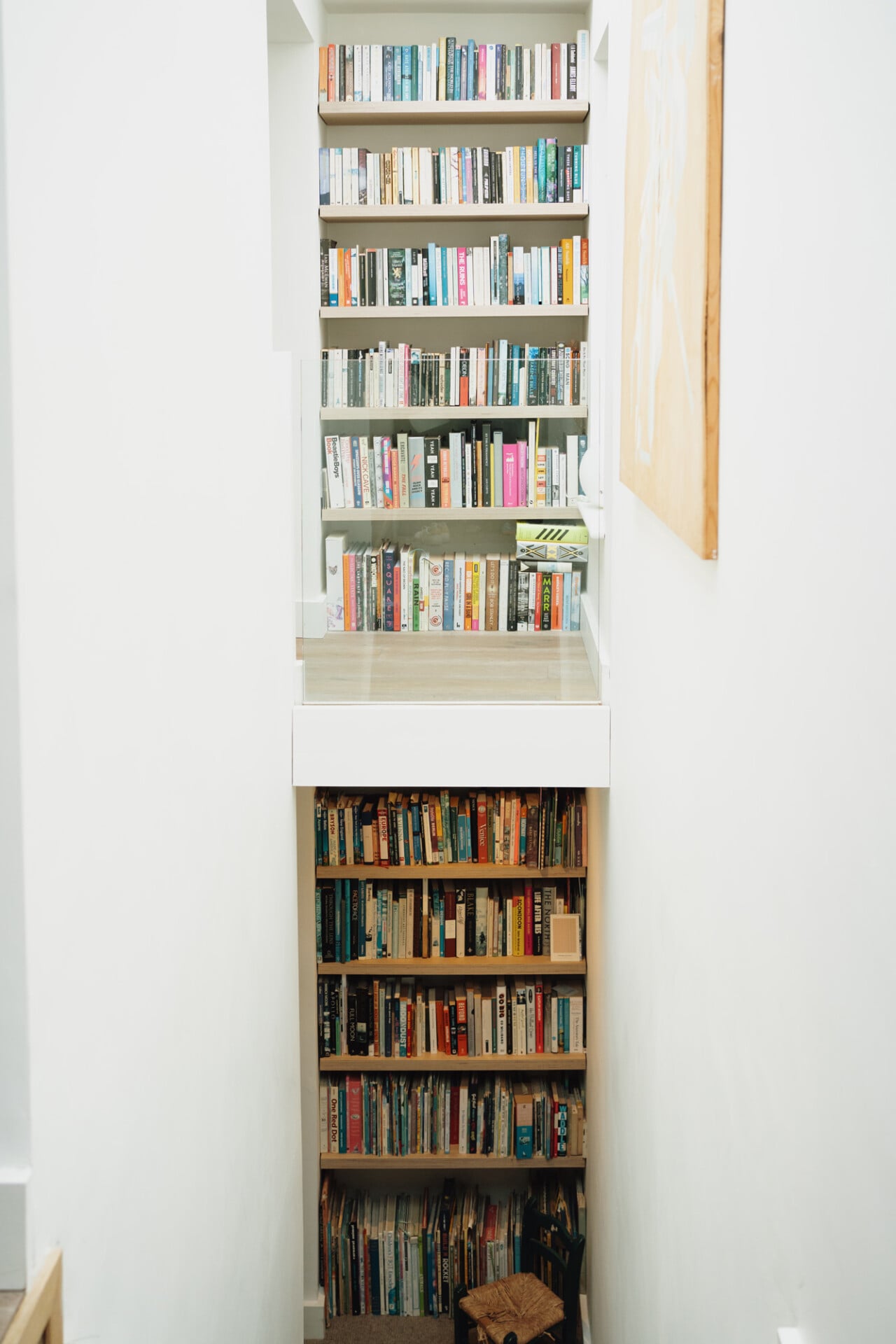 Narrow home library with floor-to-ceiling bookshelves and white walls