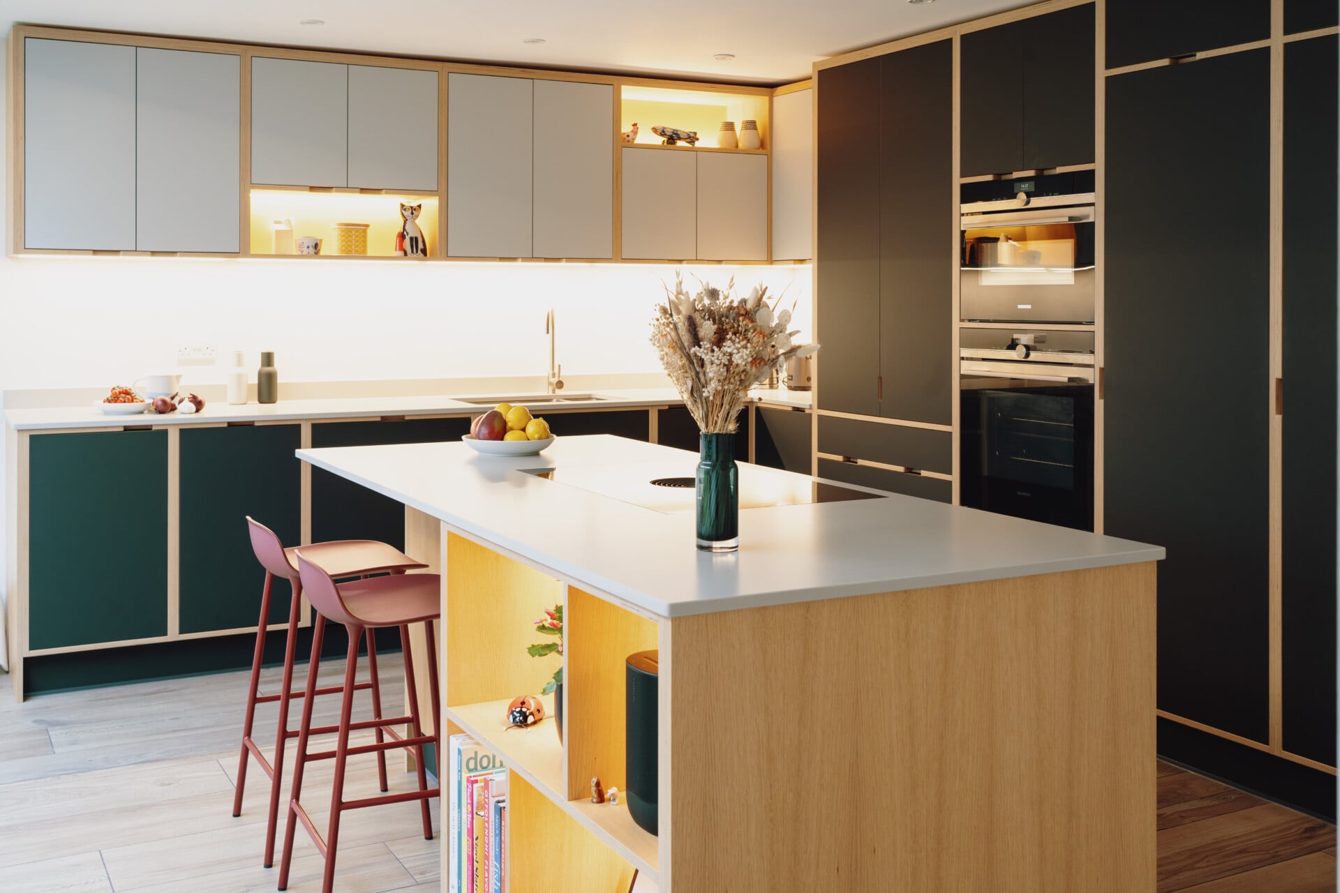 Handleless plywood kitchen with island, bar stools, and open shelving details