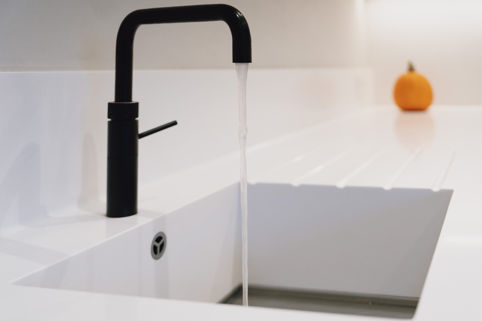 Close-up of black Quooker tap over white Corian sink