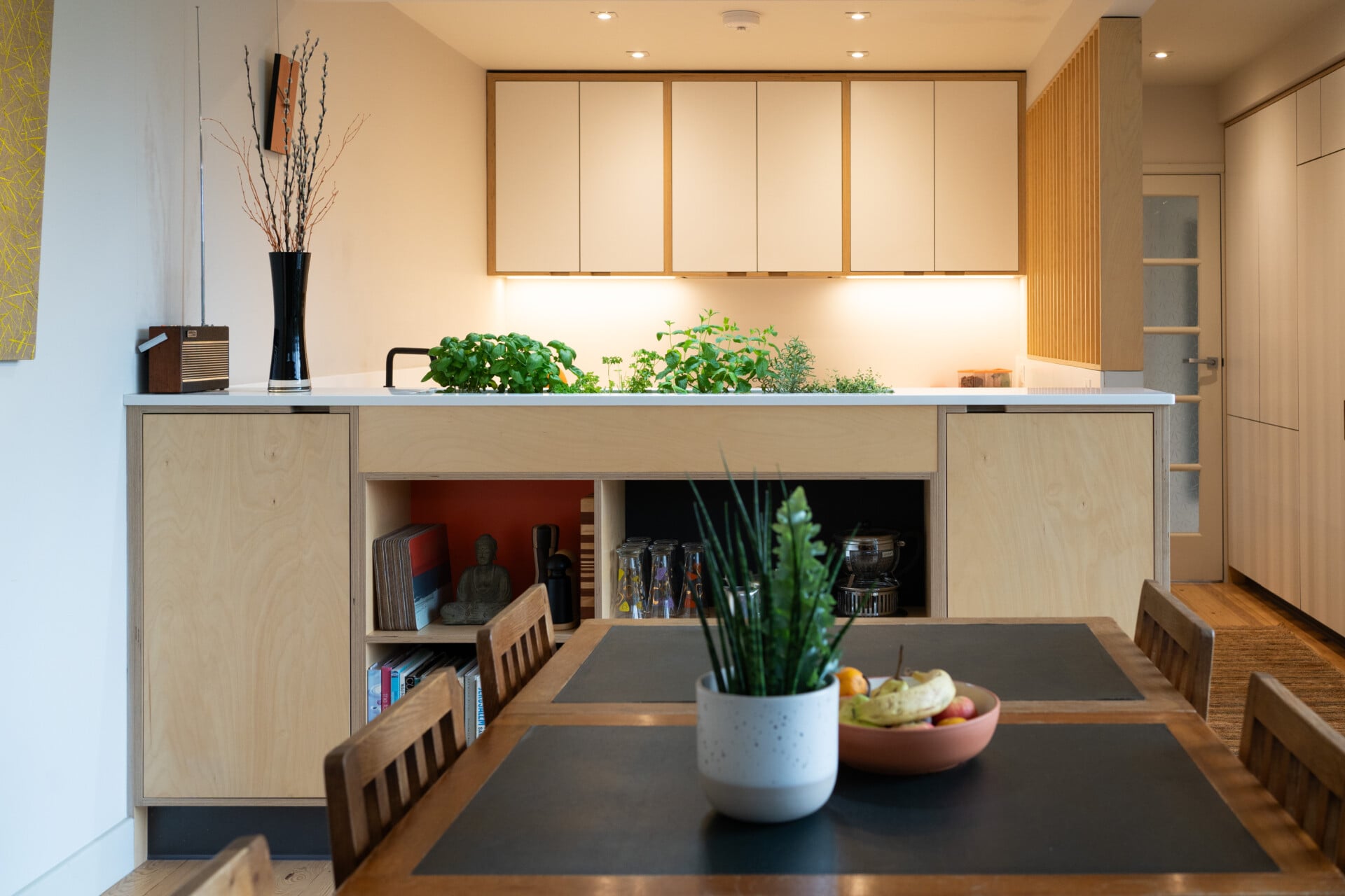 Herb planter plywood kitchen with island planter, dining table, and illuminated upper cabinets