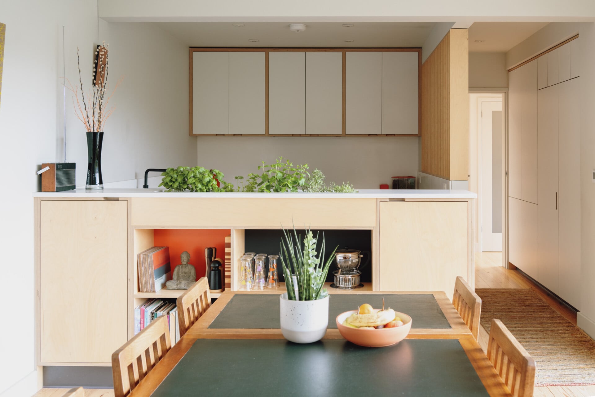 Herb planter plywood kitchen with central island, open shelving, and built-in planter