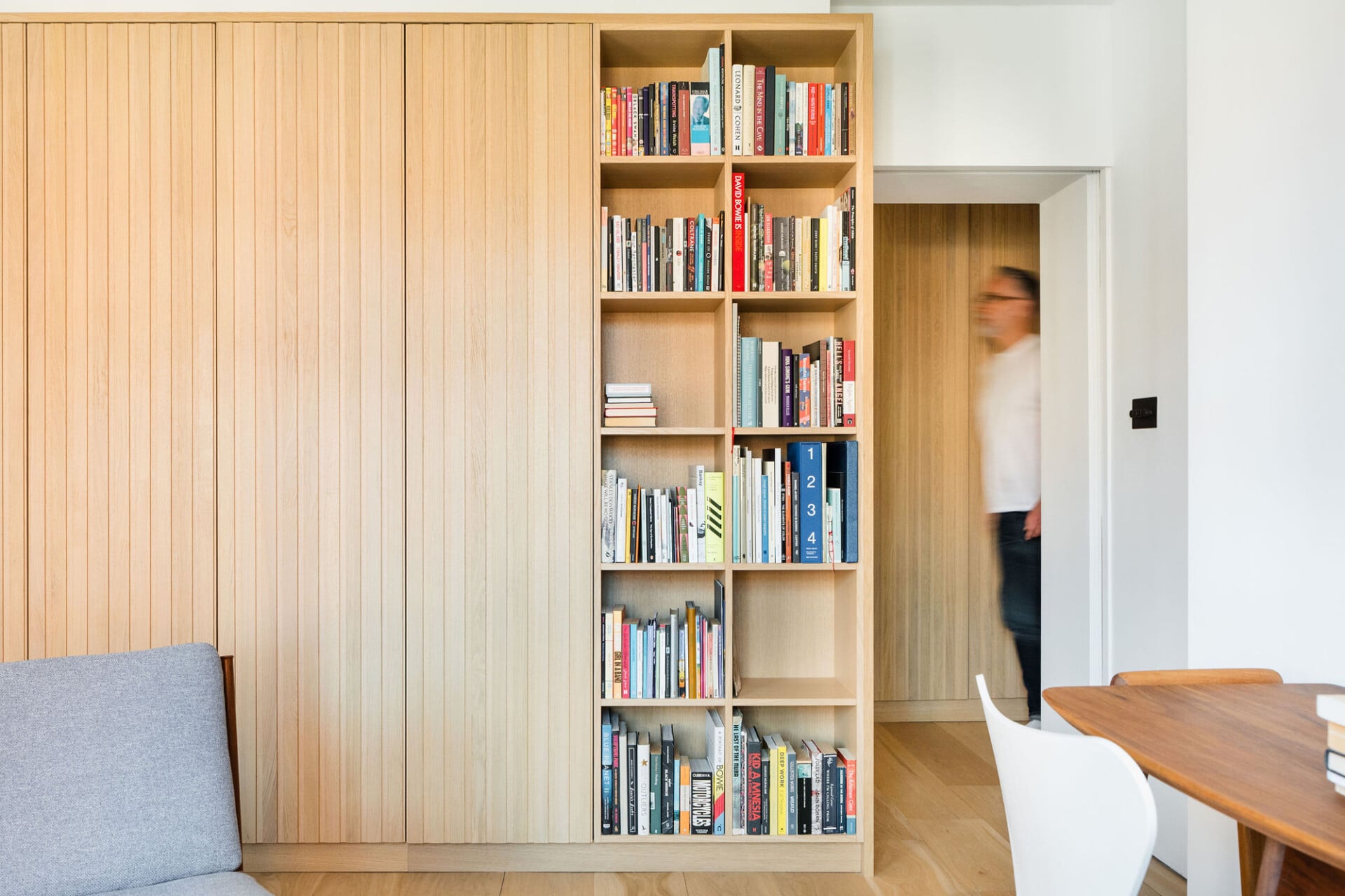 Bookshelf integrated with storage door panels in a flexible living space