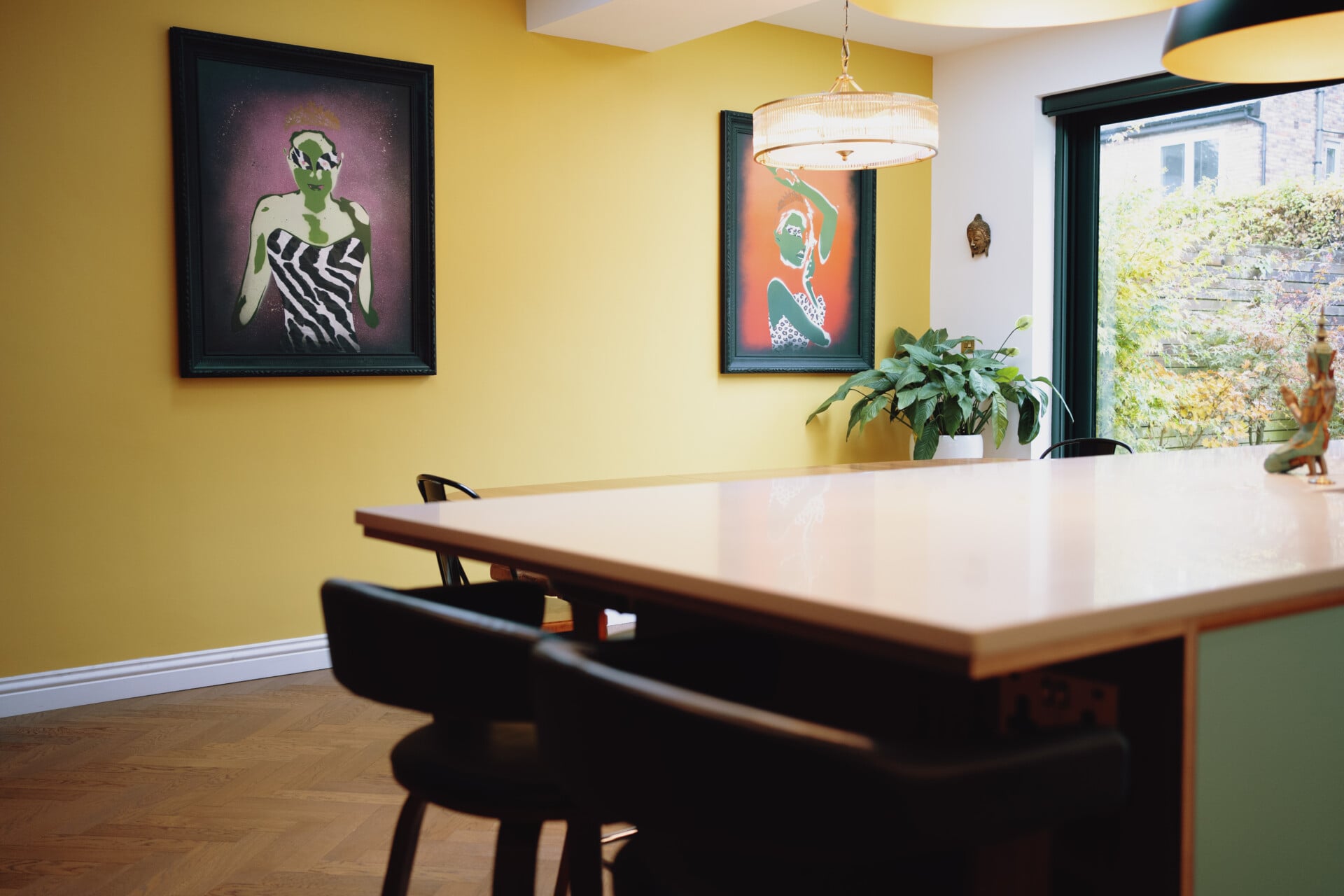 Mint green kitchen island combined with wooden dining table in colourful space