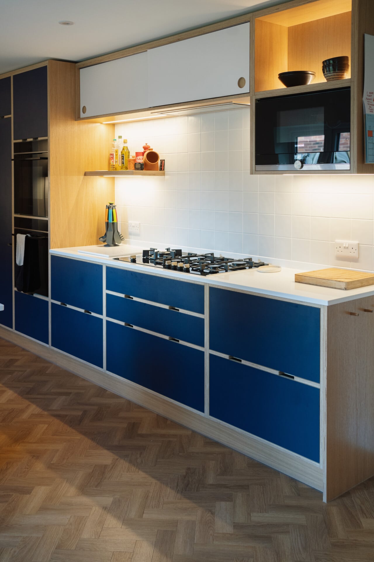 Modern blue kitchen with handleless cabinets and open shelving