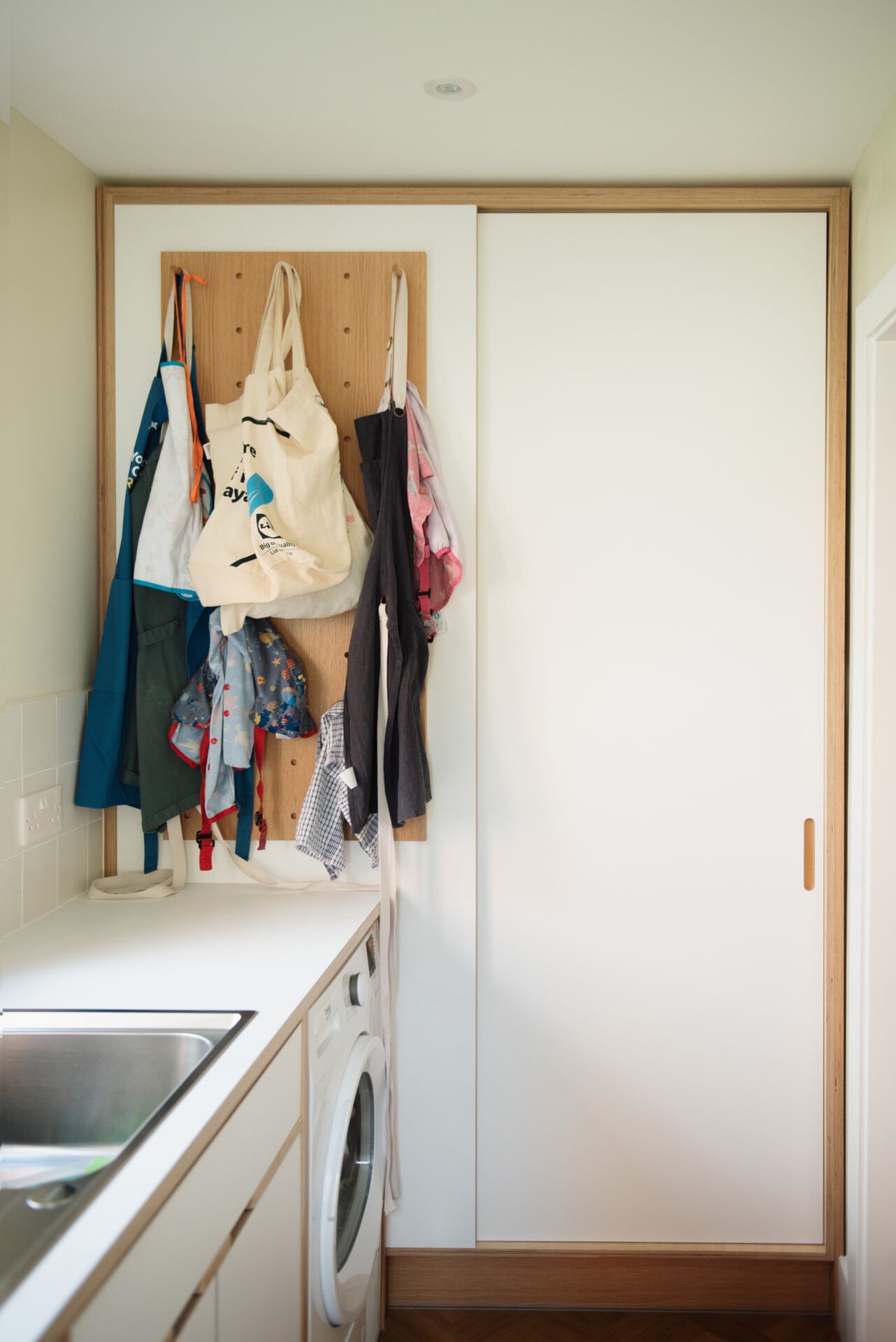 Utility room with peg board display and compact sink