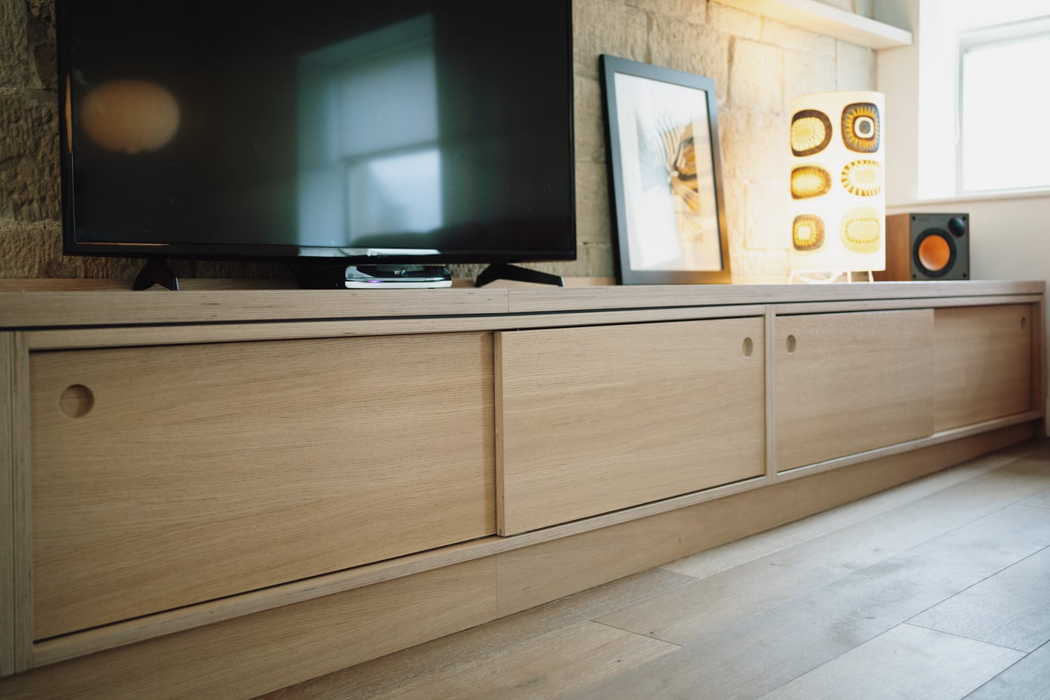 Built-in plywood storage unit with cupboards and open shelving