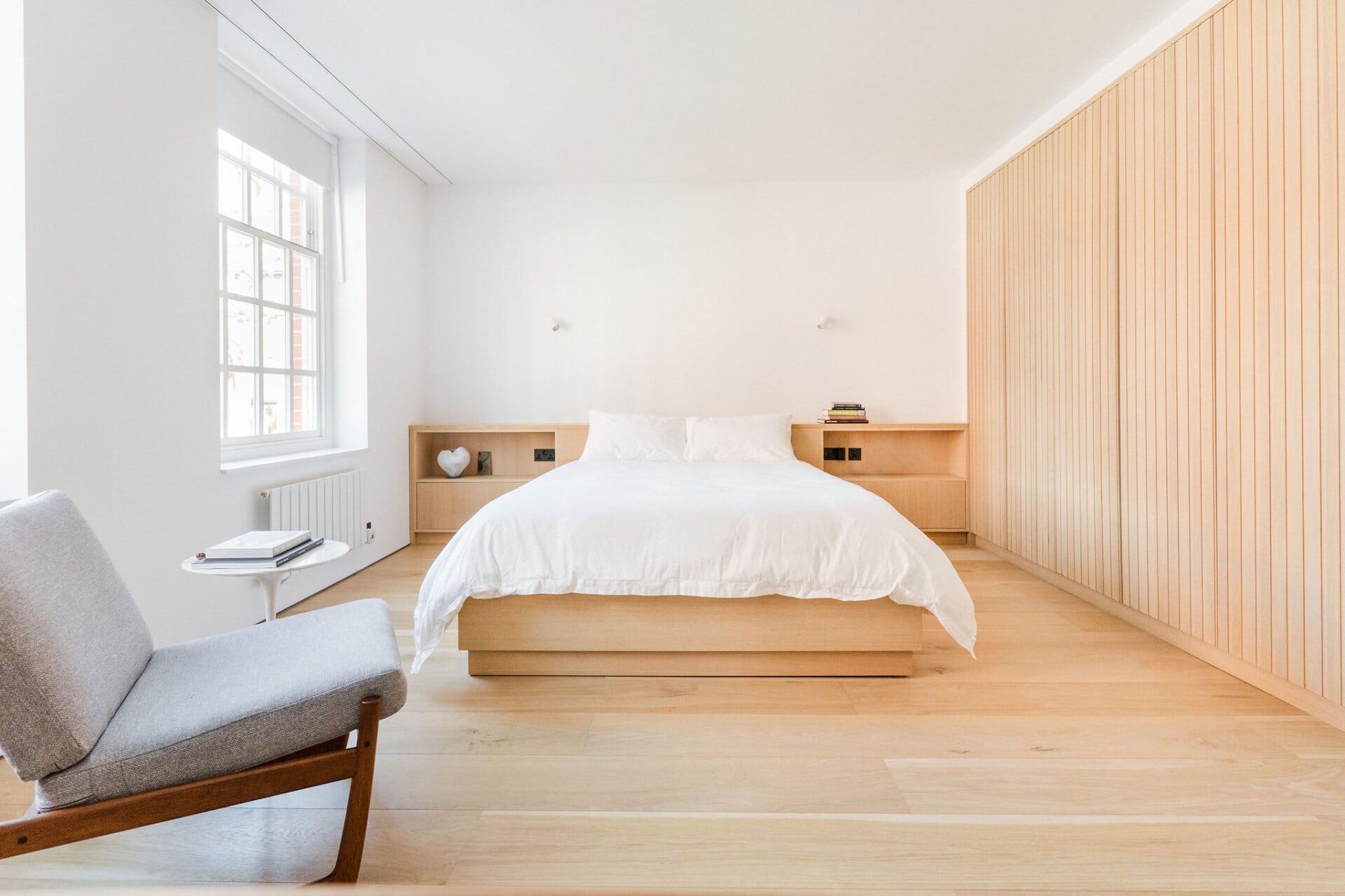 Plywood bed, headboard storage and wall-to-wall bedroom wardrobe with sliding doors and integrated handles