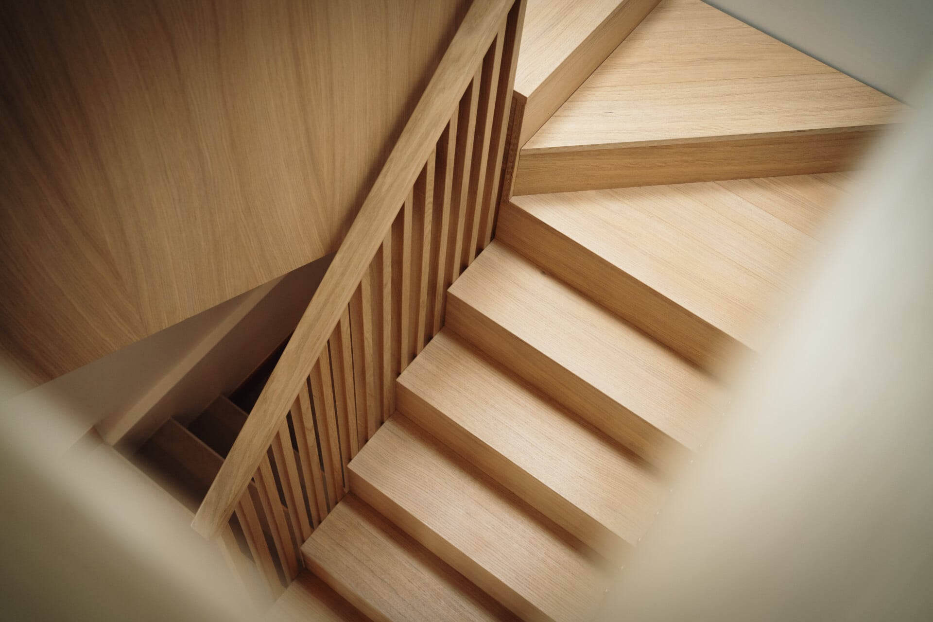 Overhead view of winding staircase with layered plywood treads