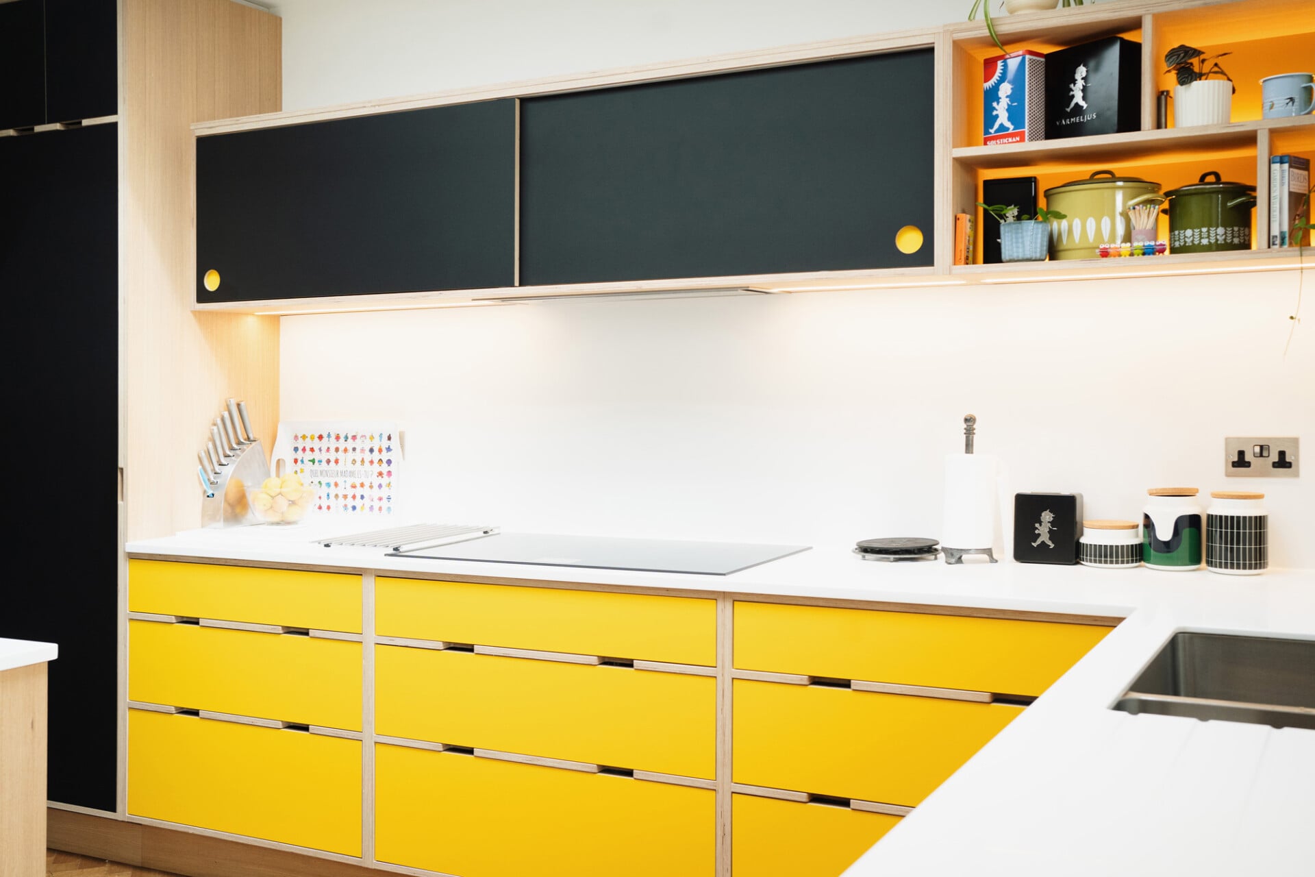 Bold yellow and black modern plywood kitchen with induction hob and wall-mounted cabinets