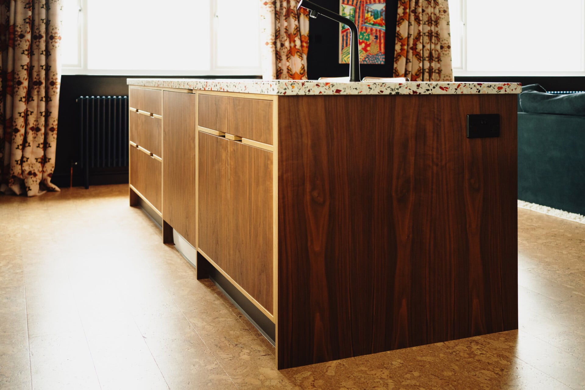 Walnut plywood kitchen island with terrazzo worktop and warm cork floors