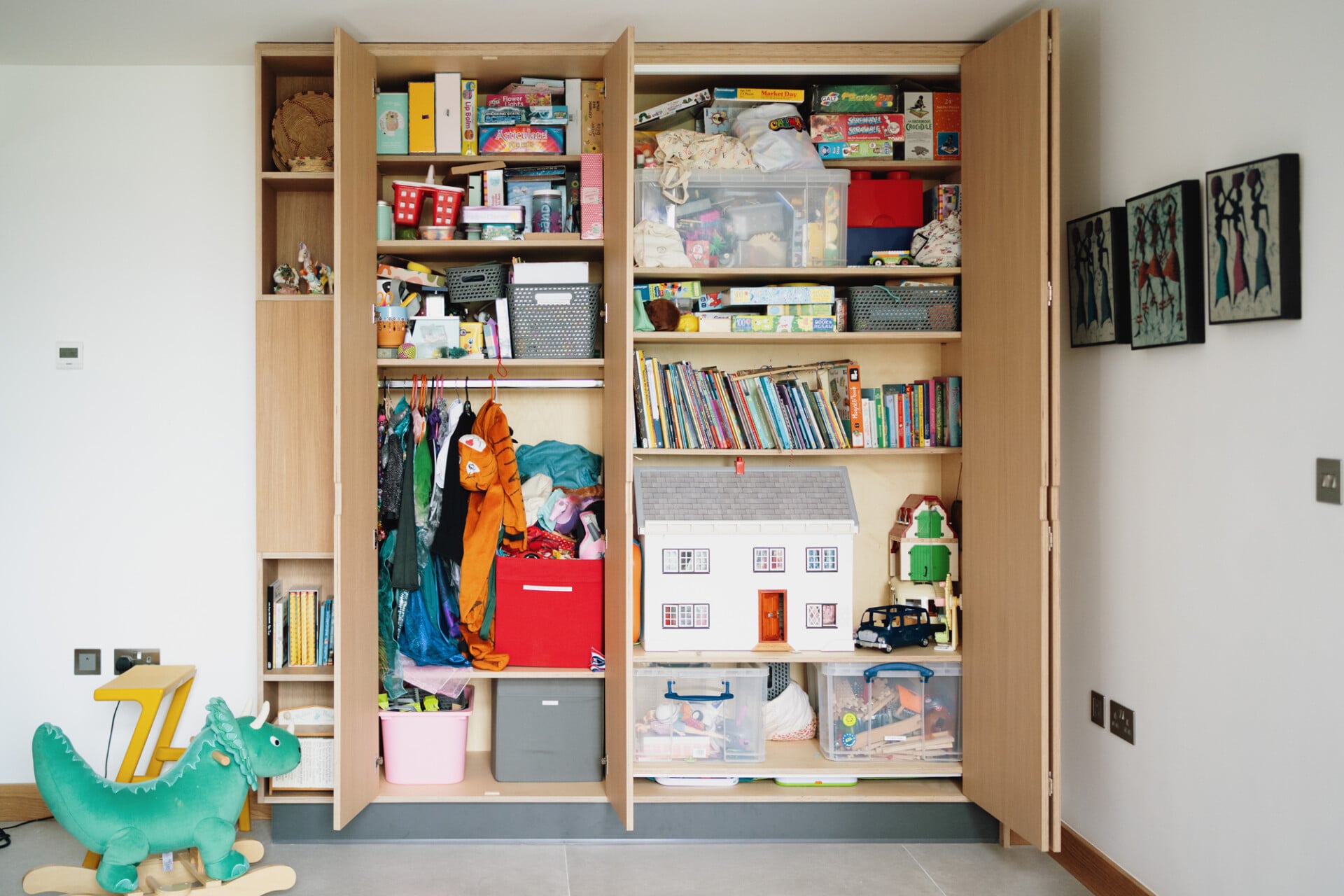 Built-in family storage unit with open shelving, toys, books,