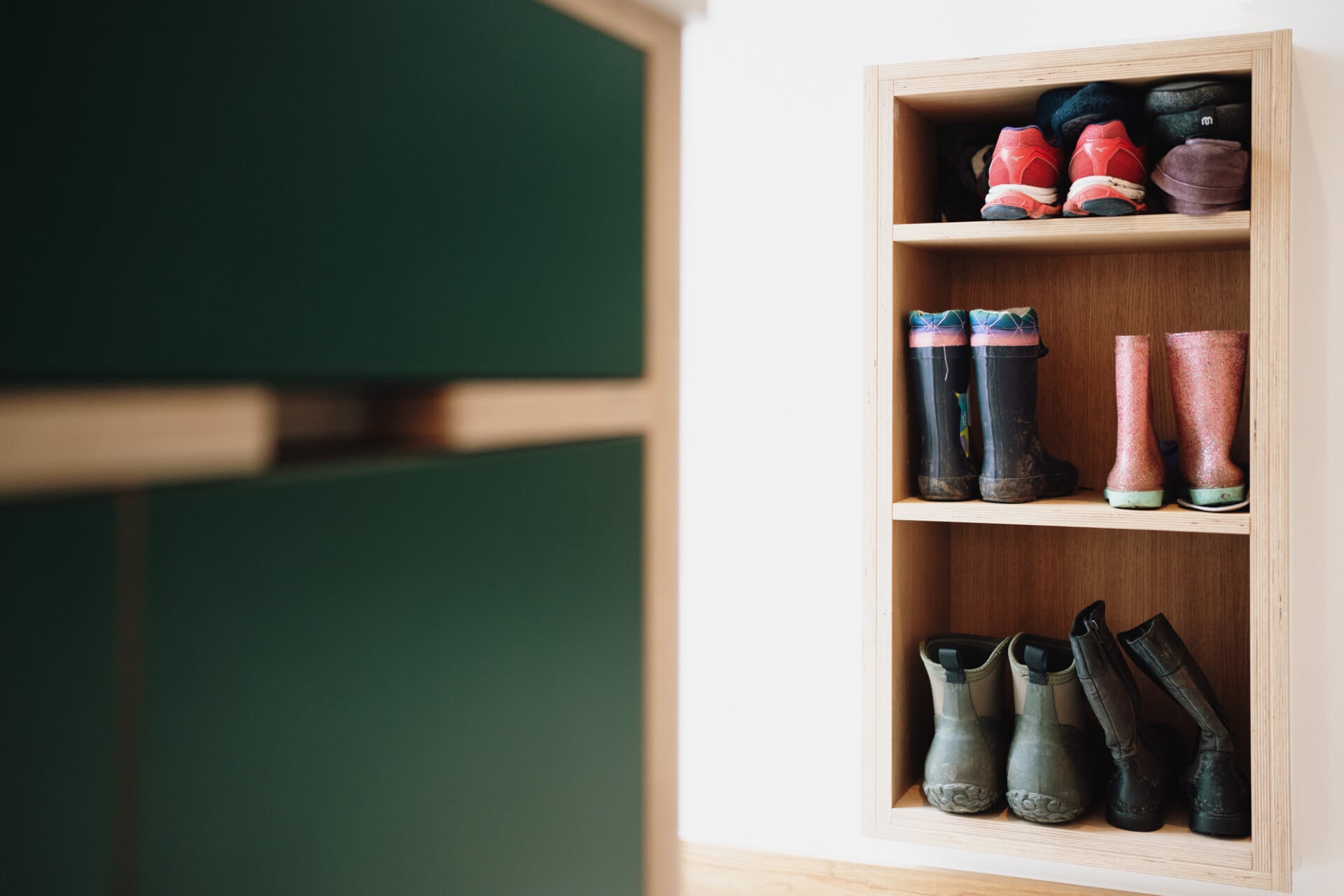 Shoe storage cubby with plywood frame and forest green cabinet fronts
